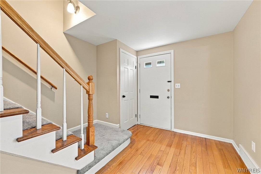 Foyer with hardwood floors and staircase at 85 Oakbrook Drive in Williamsville NY